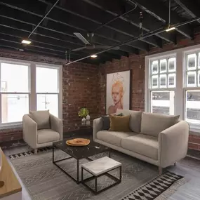 A living room with a brick wall and a large window.