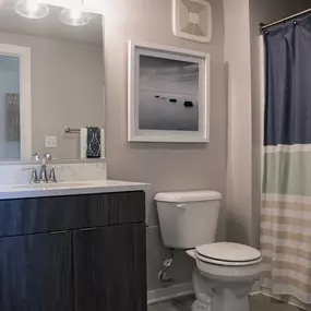 A bathroom with a toilet, sink, and shower curtain