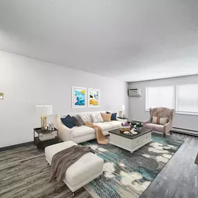 A living room with a white couch, a coffee table, and a television