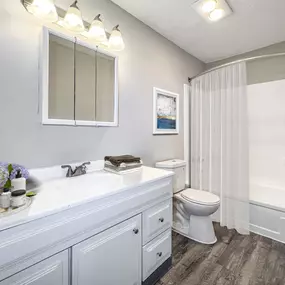 A white bathroom with a toilet, sink, and shower