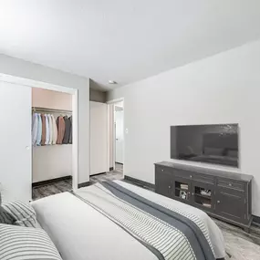 A bedroom with a bed, a wardrobe, and a television