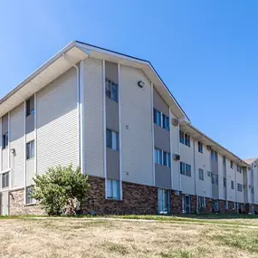 A modern apartment building with a clear blue sky above
