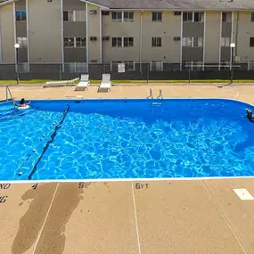 A large blue swimming pool in front of a building