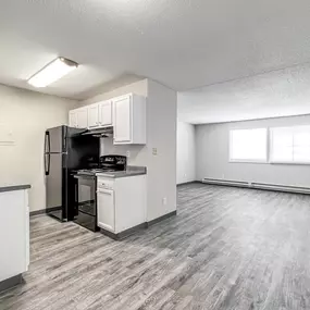 A kitchen with white cabinets and a black refrigerator