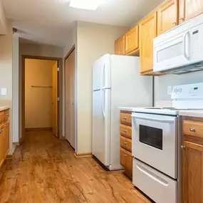 a kitchen with wood flooring and white appliances