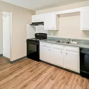 A kitchen with black appliances and white cabinets