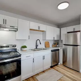 A modern kitchen with a stove, sink, and refrigerator