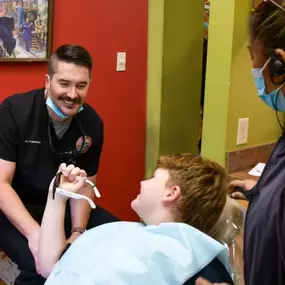 Dr. Tyler Rolland, Dentist in Broken Arrow, smiles at a young dental patient after providing care.