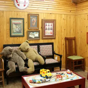 Interior view of the Edmond dental clinic's waiting room with a couch, stuffed animals, and games.
