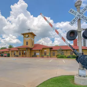 Exterior image of Dental Depot's dentist office in Midwest City, OK with a train track guard, yellow exterior, and red roof.