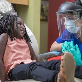 A small child talks with a dental hygienist at dental depot
