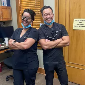 Dental Depot's North OKC Dentists strike a pose back to back with their arms crossed and big smiles.