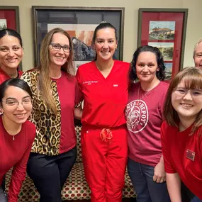 The dental team poses in red at Dental Depot's West Oklahoma City dental clinic
