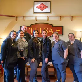 The Central Tulsa dental team poses in the reception area with big smiles
