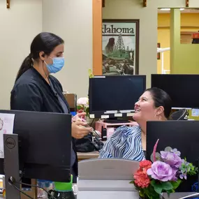 Central Tulsa's dental clinic reception desk with members of the dental team smiling.