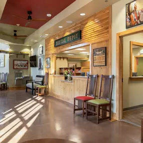 Tulsa Hills dental clinic waiting room and reception area with train themed signage and red and green furniture