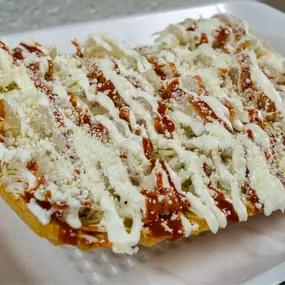 Chilindrina. Chicharrón de arina con verdura, cueritos, queso, salsa y crema.
Chilindrina. Flour cracklings with vegetables, pork rinds, cheese, sauce, and cream.