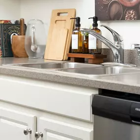a kitchen counter with a sink and a dishwasher