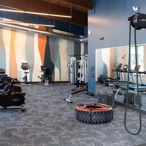 a gym with exercise equipment and a tire on the floor