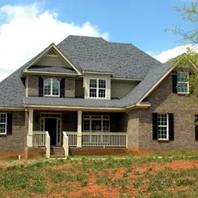New Construction Brick Home with Traditional Southern Architecture

This newly constructed custom home features a classic Southern-style design with a brick exterior, gabled rooflines, and elegant architectural details. Black shutters frame the large white-trimmed windows, enhancing curb appeal and symmetry. A spacious front porch with white railings invites warm welcomes and outdoor relaxation. The dark gray shingle roof contrasts beautifully with the earth-toned brick and siding, showcasing ti