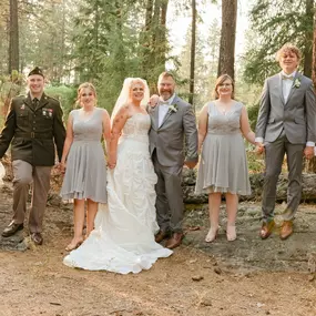 A beautifully blended family stands together in an outdoor wedding setting, symbolizing love, unity, and new beginnings. The bride and groom hold hands with their children, showcasing connection and harmony in their stepfamily journey.