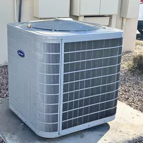An outdoor Carrier air conditioning unit installed on a concrete pad, part of a residential HVAC system serviced by Perry Mechanical Inc.