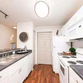 Kitchen with white cabinets and a white stove and a sink