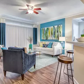 A stylish living space at Grande Club Apartments with a blue accent wall and elegant décor.