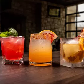 Three different colorful cocktails with beautiful garnishes