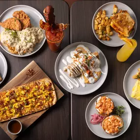 An inviting overhead view of a full brunch spread with hearty breakfast dishes, a spicy Bloody Mary, and a mimosa, ready to share and enjoy.
