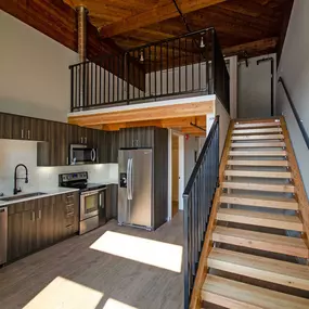 A modern kitchen with a staircase leading to the upper floor.