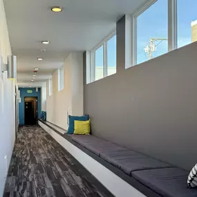 A long hallway with a bench and a door at the end.