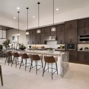 Stunning kitchens with luxury appliances, abundant counter and cabinet space, spacious islands, and generous pantries