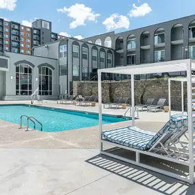 swimming pool with chairs and a building in the background
