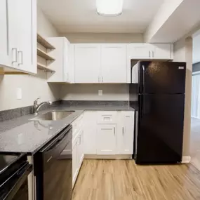 A modern kitchen with black and white appliances and cabinets