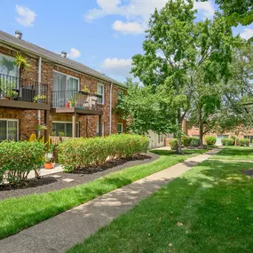 a sidewalk in front of a brick apartment building
