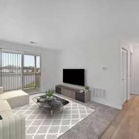 A living room with a grey sofa, a black coffee table, and a television.
