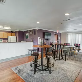 A living room with a dining area and a kitchen with a table and chairs