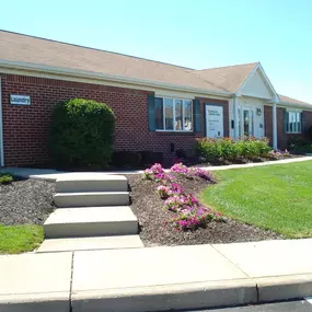 The front of a house with steps leading up to the front yard