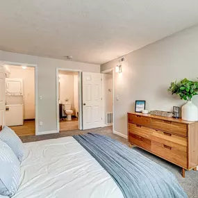 A bedroom with a bed, dresser, and mirror.