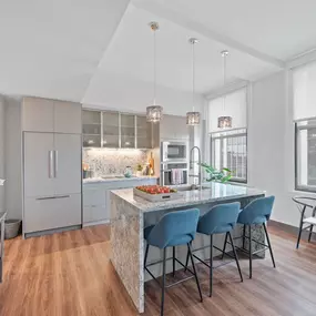 A modern kitchen with a refrigerator, oven, and microwave