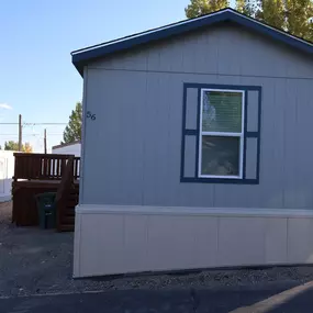 a small gray shed with a window and a deck