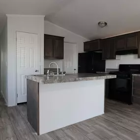 an empty kitchen with an island in the middle of it