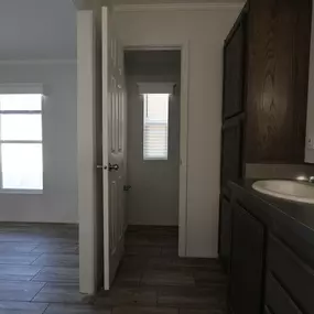 an empty bathroom with a sink and a door to a hallway