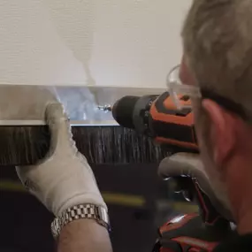 a property owner installing an Xcluder rodent-proof door bottom