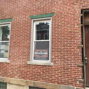 A brick building facade with a window displaying a 