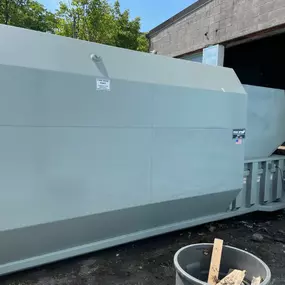 Self-contained compactor with rear-feed hopper