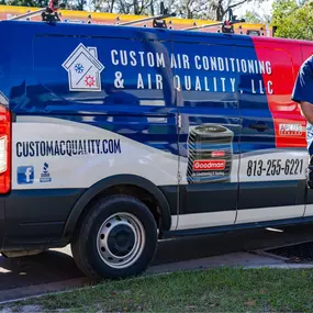 A Custom Air Conditioning service tech working on an AC unit at a customer's house in Zephyrhills