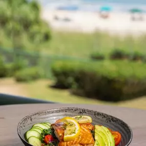 Grilled filet of fish on display at Reel Food & Drinks with a beach view in the distance