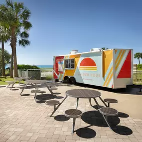 The Golden Hour Pool Bar with picnic tables and palm trees